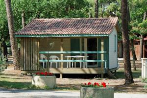 滨海苏拉克Camping Les Oyats的公园里摆放着椅子和鲜花的小棚子