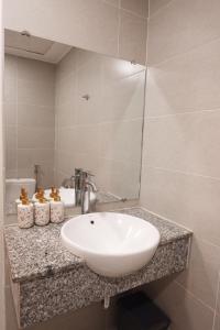 une salle de bains avec un lavabo blanc et un miroir dans l'établissement The Rustic Home - Room 2, à Hô-Chi-Minh-Ville