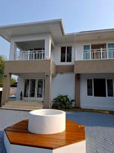 ein großes weißes Haus mit einem Tisch davor in der Unterkunft The Lanna Lagoon เดอะลานนา ลากูน in Chiang Mai