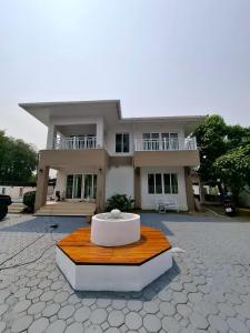 ein Haus mit einem Tisch davor in der Unterkunft The Lanna Lagoon เดอะลานนา ลากูน in Chiang Mai