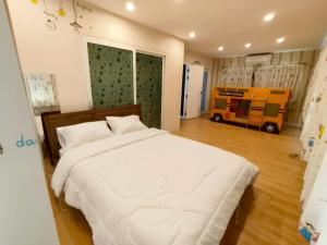 ein Schlafzimmer mit einem weißen Bett und einem gelben Bus in der Unterkunft The Lanna Lagoon เดอะลานนา ลากูน in Chiang Mai