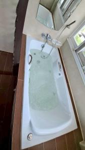 ein Bad mit einer Badewanne mit Wasser in der Unterkunft The Lanna Lagoon เดอะลานนา ลากูน in Chiang Mai + 3 Fotos