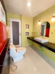 ein Badezimmer mit einer weißen Toilette und einem Waschbecken in der Unterkunft The Lanna Lagoon เดอะลานนา ลากูน in Chiang Mai