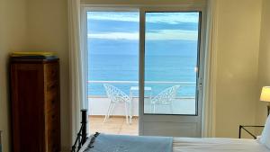 a bedroom with a door open to a balcony with chairs at Beira Mar by Check-in Portugal in Albufeira +13 photos