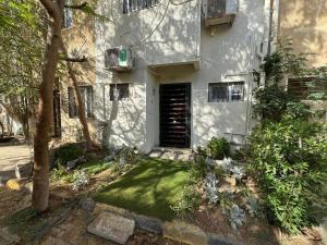 una casa blanca con un patio con un pequeño patio sidx sidx sidx en 203 · Charming 2BR Townhouse, en Sheikh Zayed