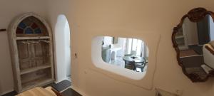 a hallway with a mirror and a dining room at Aliori art caves in Aegiali