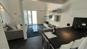 a kitchen and living room with a table and a couch at Elegant loft by the sea in Punta Marina