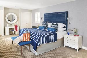 a bedroom with a blue and white bed and a desk at Harbour Hotel & Spa Christchurch in Christchurch
