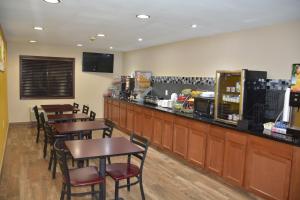 a restaurant with wooden tables and chairs and a bar at Super 8 by Wyndham Webster City IA in Webster City