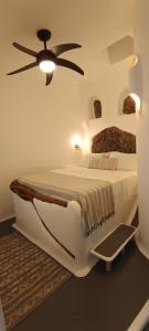 a bedroom with a large bed with a ceiling fan at Aliori art caves in Aegiali