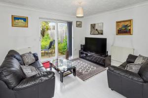 Enfield LockにあるUrban Oasis - Modern 2B/2B Retreat Near Natureのリビングルーム(革張りのソファ2台、テレビ付)