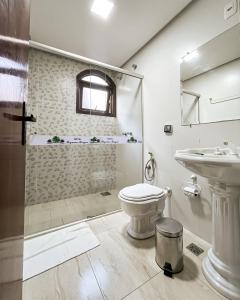a bathroom with a shower and a toilet and a sink at Hotel Pequeno Bosque in Gramado +36 photos