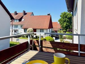 a balcony with a cup of coffee on a table at Ferienwohnung Kleine Seeperle - Ihr Rückzugsort in Nonnenhorn in Nonnenhorn
