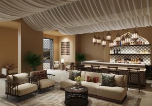 古城扎耶德Aldhafra Resort, Vignette Collection by IHG的大堂里摆放着沙发，背景是酒吧