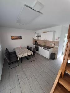 a living room with a table and chairs and a kitchen at Apartma Zala in Brežice