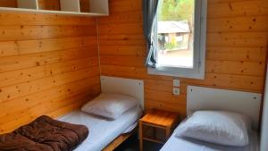 滨海苏拉克Camping Les Oyats的一间木墙房间里有两张床
