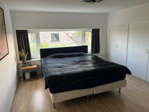 a bedroom with a bed with a black comforter at Enjoy in Wenduine