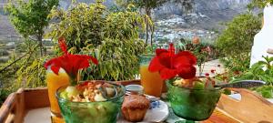 a table with two vases filled with food and flowers at Aliori art caves in Aegiali