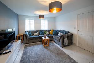 a living room with a couch and a table at Spacious 4BD Home with Patio garden, BBQ & Parking in Timsbury