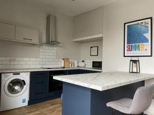 a kitchen with a counter and a washing machine at Comfy 1BD Retreat in the Heart of Alderley Edge in Alderley Edge