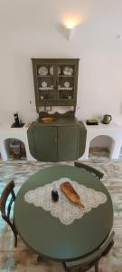 a room with a green table with a bowl on it at Aliori art caves in Aegiali