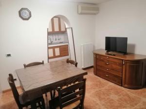 a dining room with a table and a television on a dresser at Casa Vacanze da Melina in Taranto