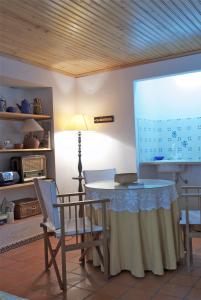 a room with a table and chairs and a screen at Casa de Sines in Sines