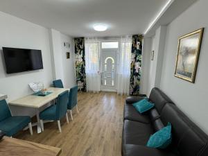 un salon avec un canapé et une salle à manger dans l'établissement Vila Kraljica 2- apartman 9, à Bukorovac