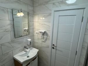 une salle de bain blanche avec un lavabo et un miroir dans l'établissement Vila Kraljica 2- apartman 9, à Bukorovac 7 autres photos