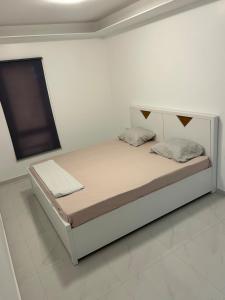 a white bedroom with a bed in a room at Appartement T 3 aéroport Nelson Mandela Paria in Praia