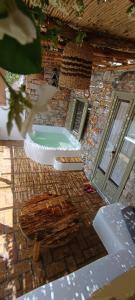 a stone building with a bath tub in a room at Aliori art caves in Aegiali