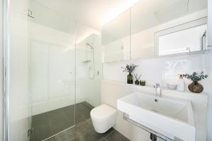 Un baño blanco con inodoro y lavabo. en Jam Home Darlinghurst Central 1 Secure Parking, en Sídney 8 fotos más