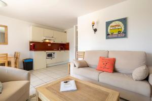 a living room with a couch and a table at Beg Meil centre, 300 m de la plage in Fouesnant