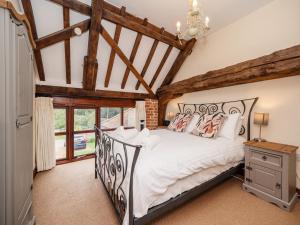 a bedroom with a large bed and wooden ceilings at Maple Barn: Lux Rural Retreat Near Norfolk Coast in Sutton