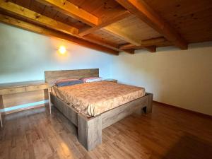 Un dormitorio con una cama en una habitación con techos de madera. en The Music of The Lake - Lake Front with three Bedrooms, en Dongo
