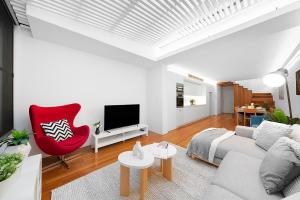 a living room with a couch and a red chair at Designer Darlinghurst Retreat Garage Parking in Sydney