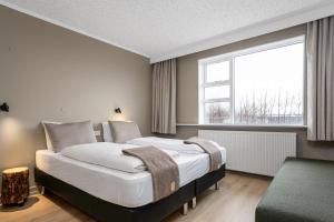 海拉Stracta Hotel Mosfell的一间带大床和窗户的卧室