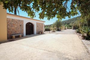 a courtyard with a building with a door and a bench at Ca na Margalida in Manacor