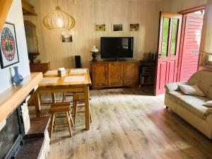 a living room with a couch and a table and a tv at Masuria Hut in Mrągowo