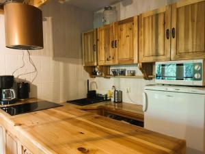 a kitchen with wooden cabinets and a white refrigerator at Masuria Hut in Mrągowo