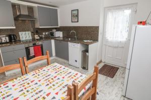 a kitchen with a table and a kitchen with a refrigerator at Sea View Loft in Penzance