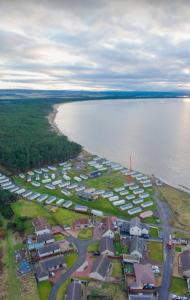 an aerial view of a resort next to a body of water at Northern Light Villa, forest, beach and bubbles in Burghead