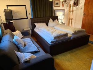 a bed and a couch in a living room at Apartment Thomabauerhof in Oberzeiring +15 photos
