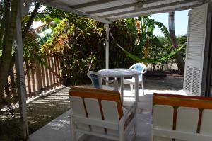 Un patio con una mesa y sillas en un porche. en Green Garden Apartment, en Christ Church