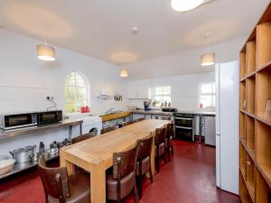 a large kitchen with a wooden table and chairs at YHA Coniston Coppermines in Coniston