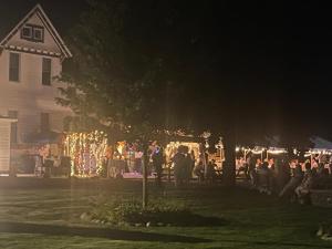 a group of people standing outside of a house at night at Lake Huron Lodge in Lexington