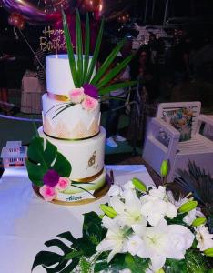 a three tiered wedding cake on a table with flowers at Hotel B&B Des Bains Milano Marittima in Milano Marittima +127 photos