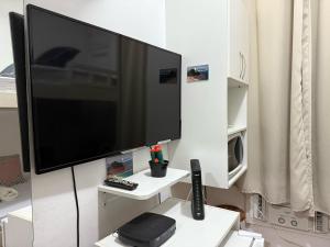 a large flat screen tv on a white wall at Quarto Leme in Rio de Janeiro