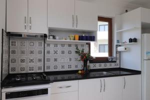a kitchen with white cabinets and a black counter top at Blackwood Flava Cora in Datca