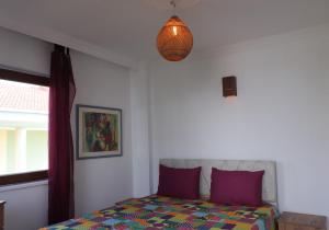 a bedroom with a bed with purple pillows and a lamp at Blackwood Flava Cora in Datca